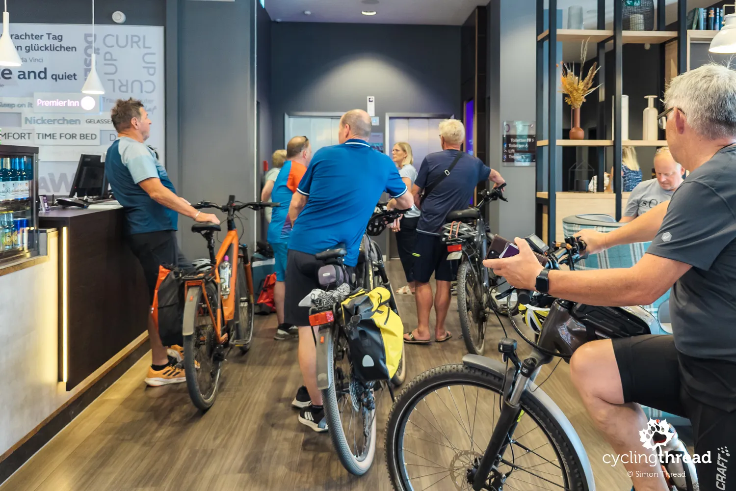 A queue of cyclists at a hotel reception